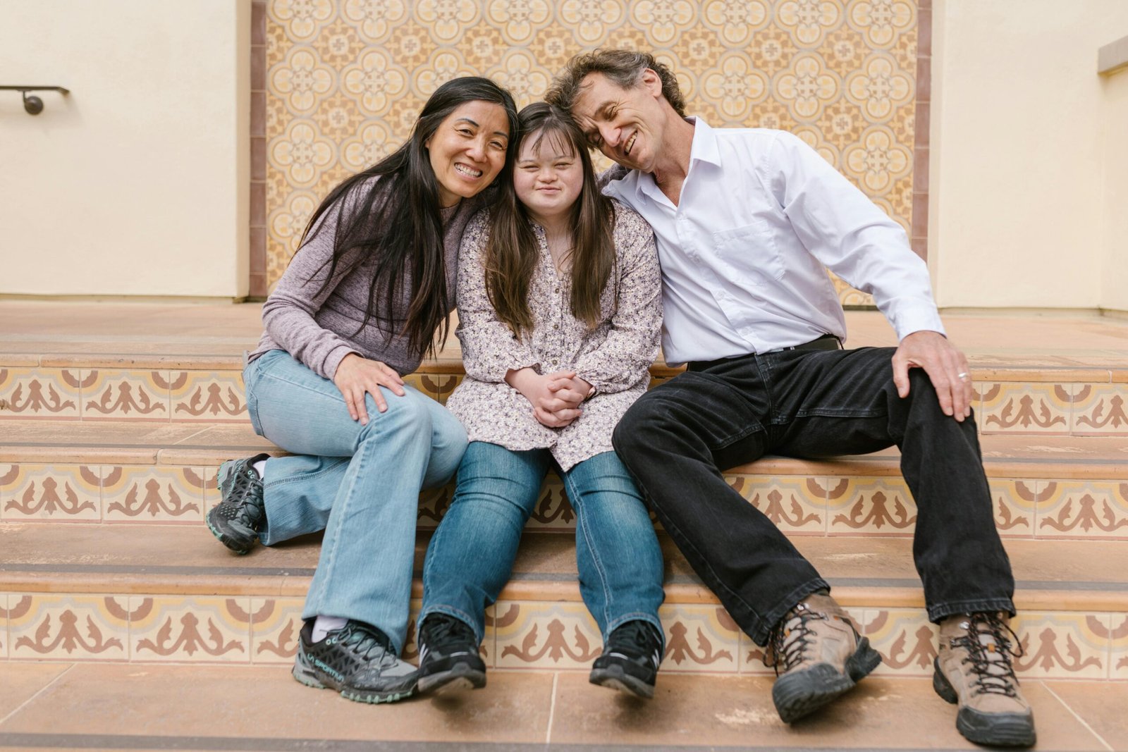 A loving family enjoys a bonding moment together, sitting on decorative outdoor stairs.